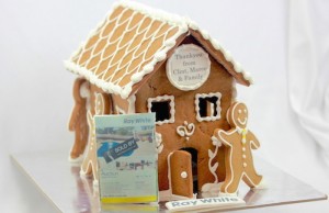 Real estate gingerbread house with sold sign and gingerbread people on it